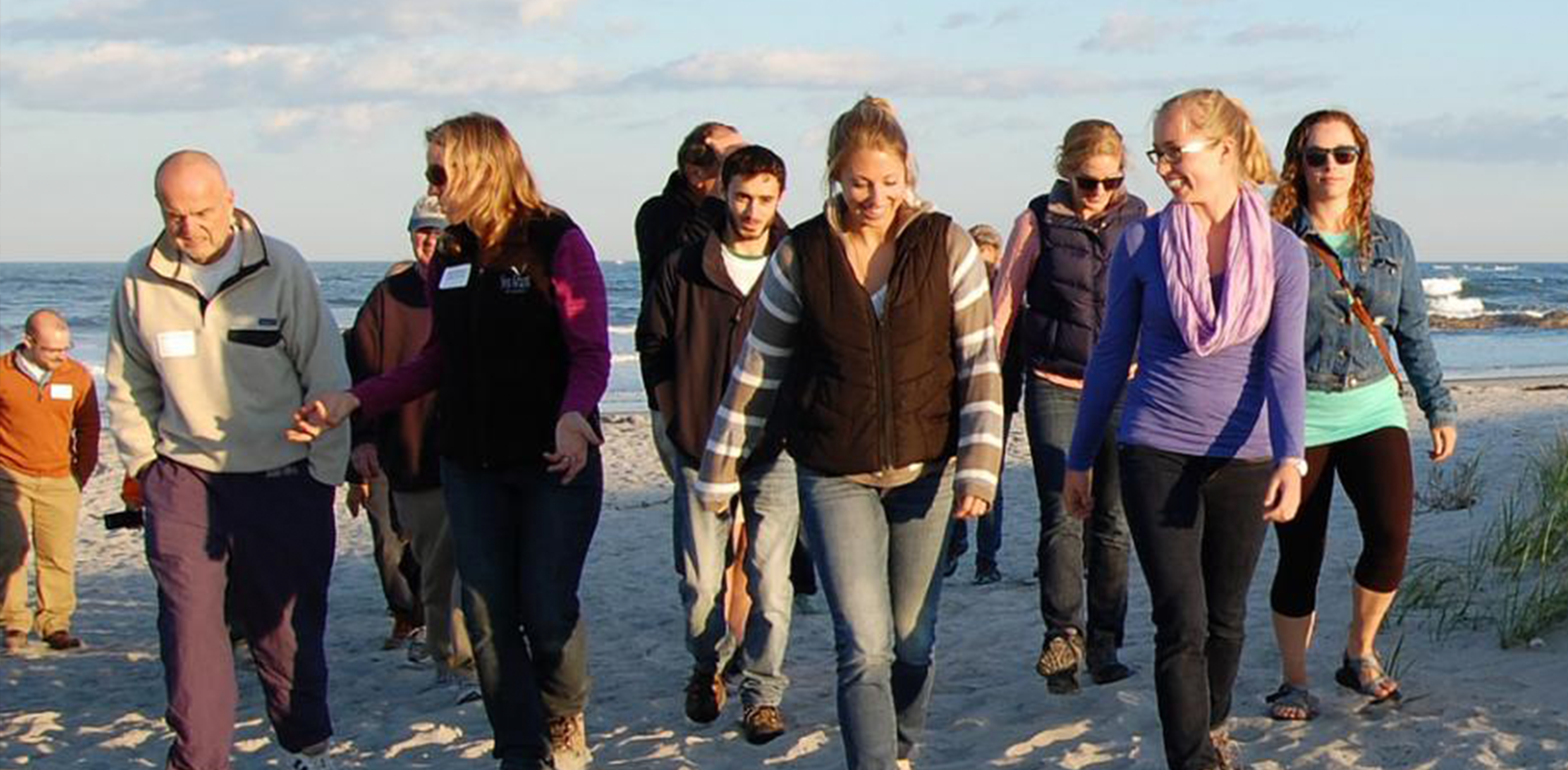 students in the coastal policy graduate certificate program walking on the beach