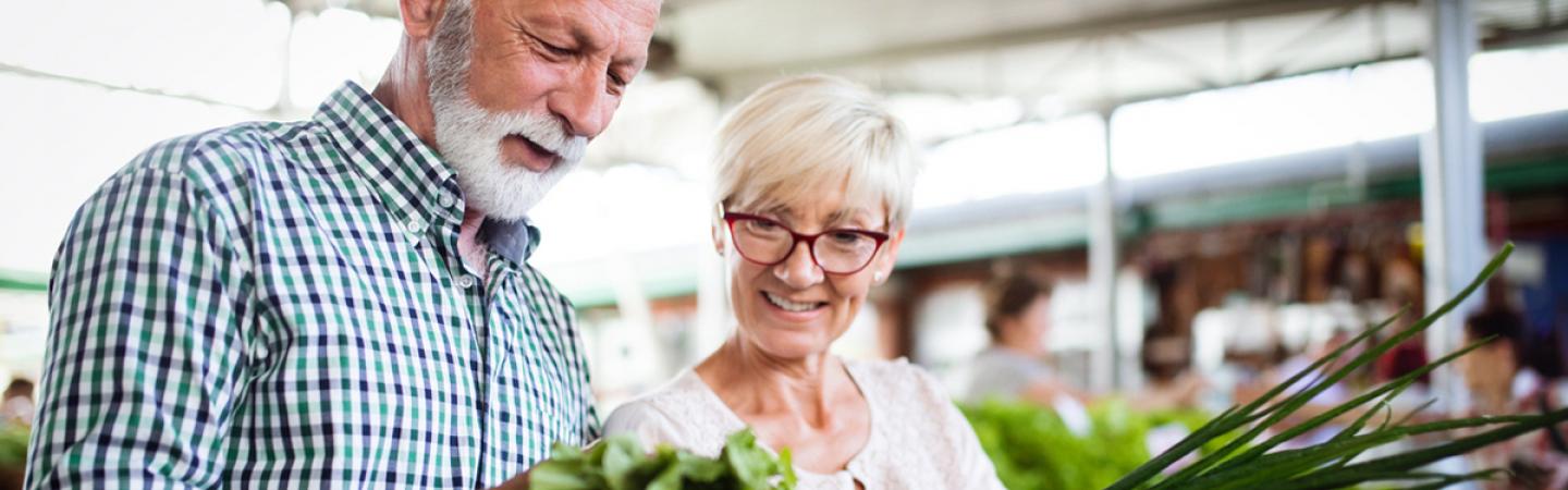 A mature couple looking at vegetables at a farmer's market