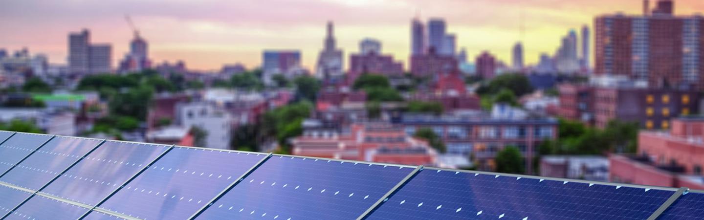 A photo of a solar installation on a home with a city in the background