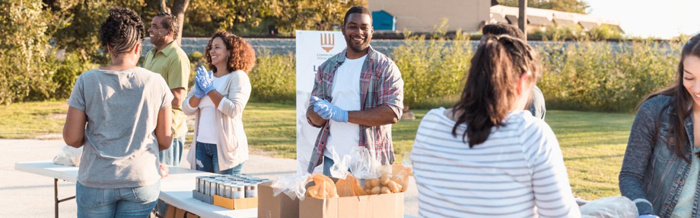 A photo of a diverse group of people participating in a food drive for a local food bank