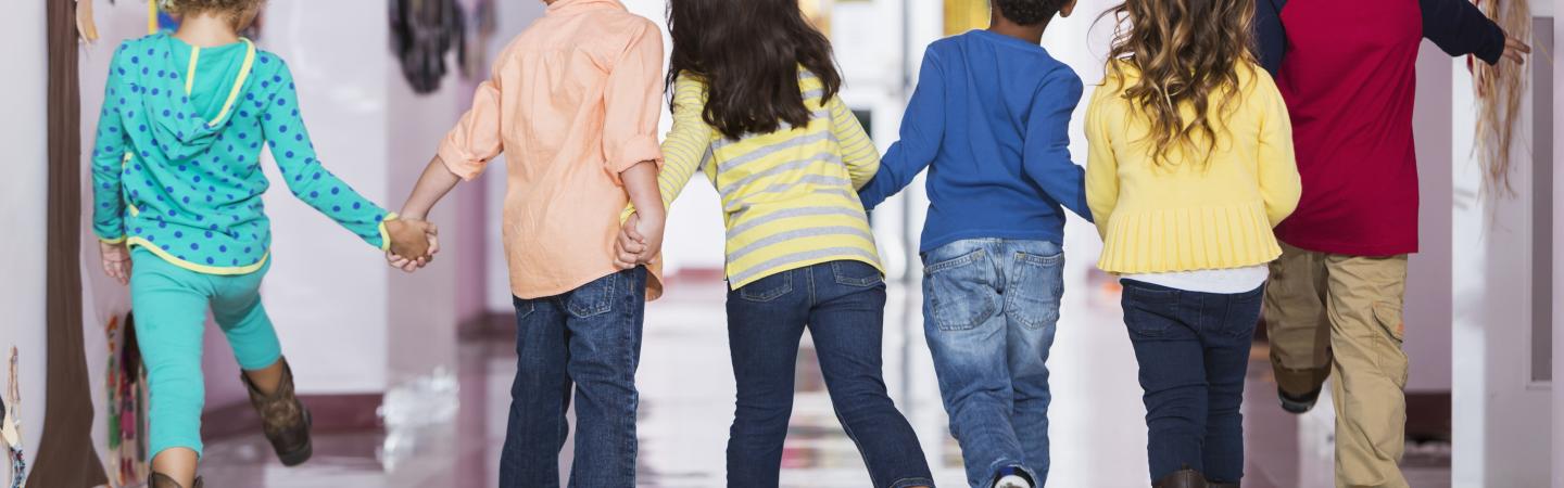 Image of Preschoolers Holding Hands and Walking Down School Hallway