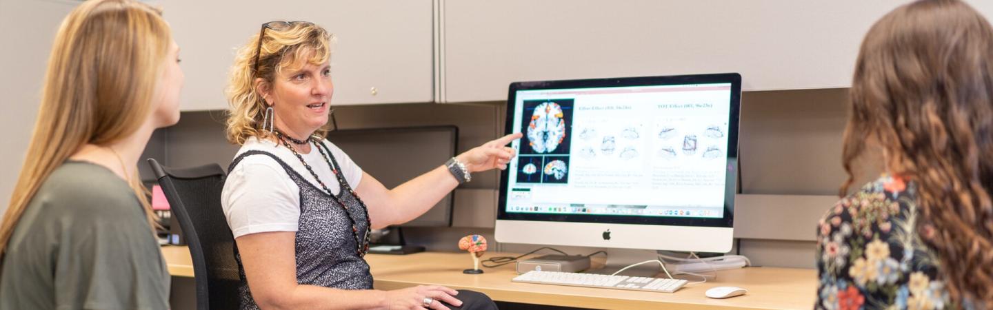 Community medicine instructor pointing at CT scan image