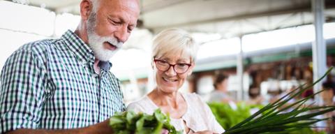 A mature couple looking at vegetables at a farmer's market