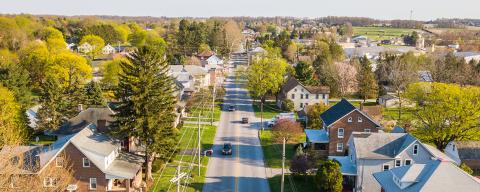 a road in a rural pennsylvania community with cars passing through