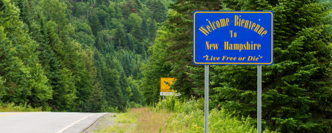 welcome to nh sign on scenic evergreen laden mountain road