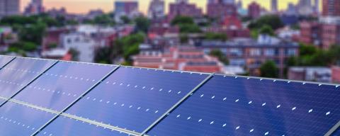 rooftop solar panels with cityscape in background