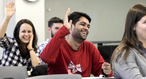 Students raising their hands in a Public Policy class.