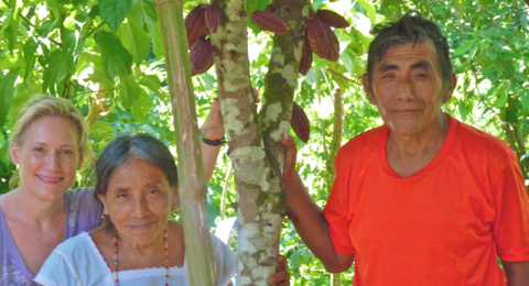 Robin with a man and a women standing among cacao trees.