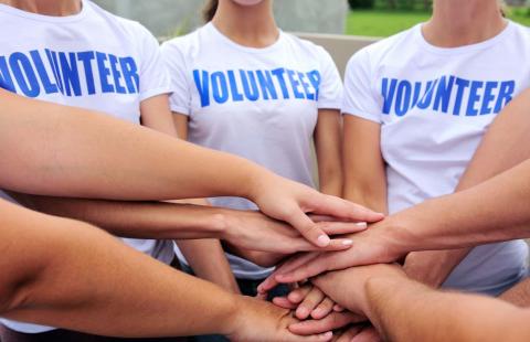 A photo showing people wearing shirts that say "Volunteer"