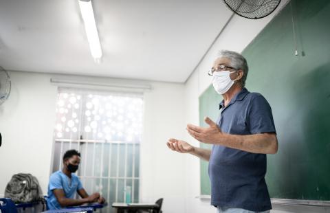 A public educator speaks to a class of students during the COVID-19 pandemic