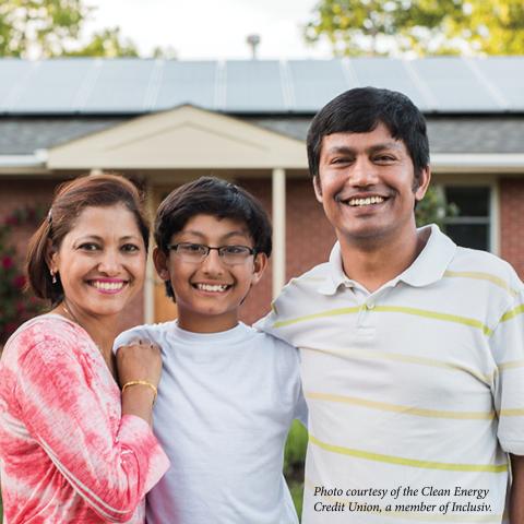 image of mother, son, and father in front of home with solar panels