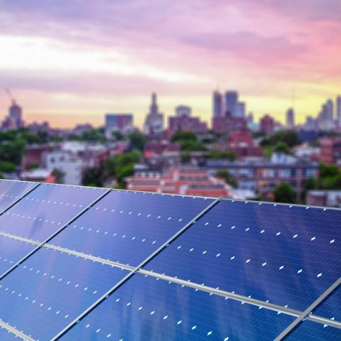 image of solar panels with city landscape