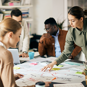 group of four people looking over data, brainstorming