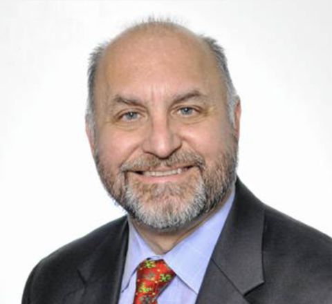 Rob Werner in front of white background with suit.