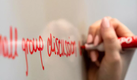 person writing on a white board