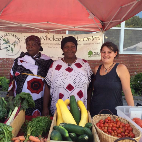 MCD graduate Charlene Higgins (far right) standing with vegetable vendors.