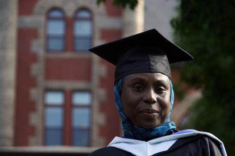 Safiya Adamu stands in her graduation cap in front of Carsey