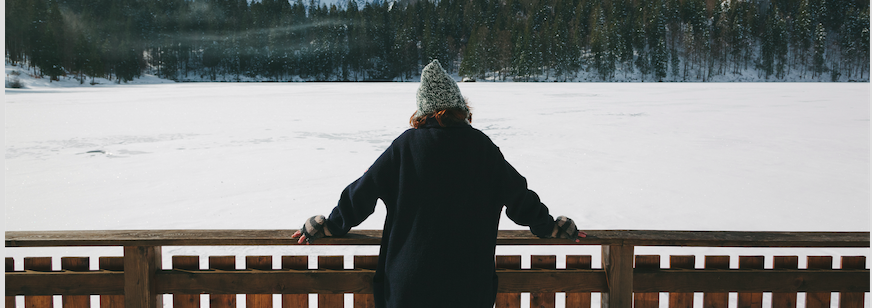 Image of a woman looking a snow covered lake