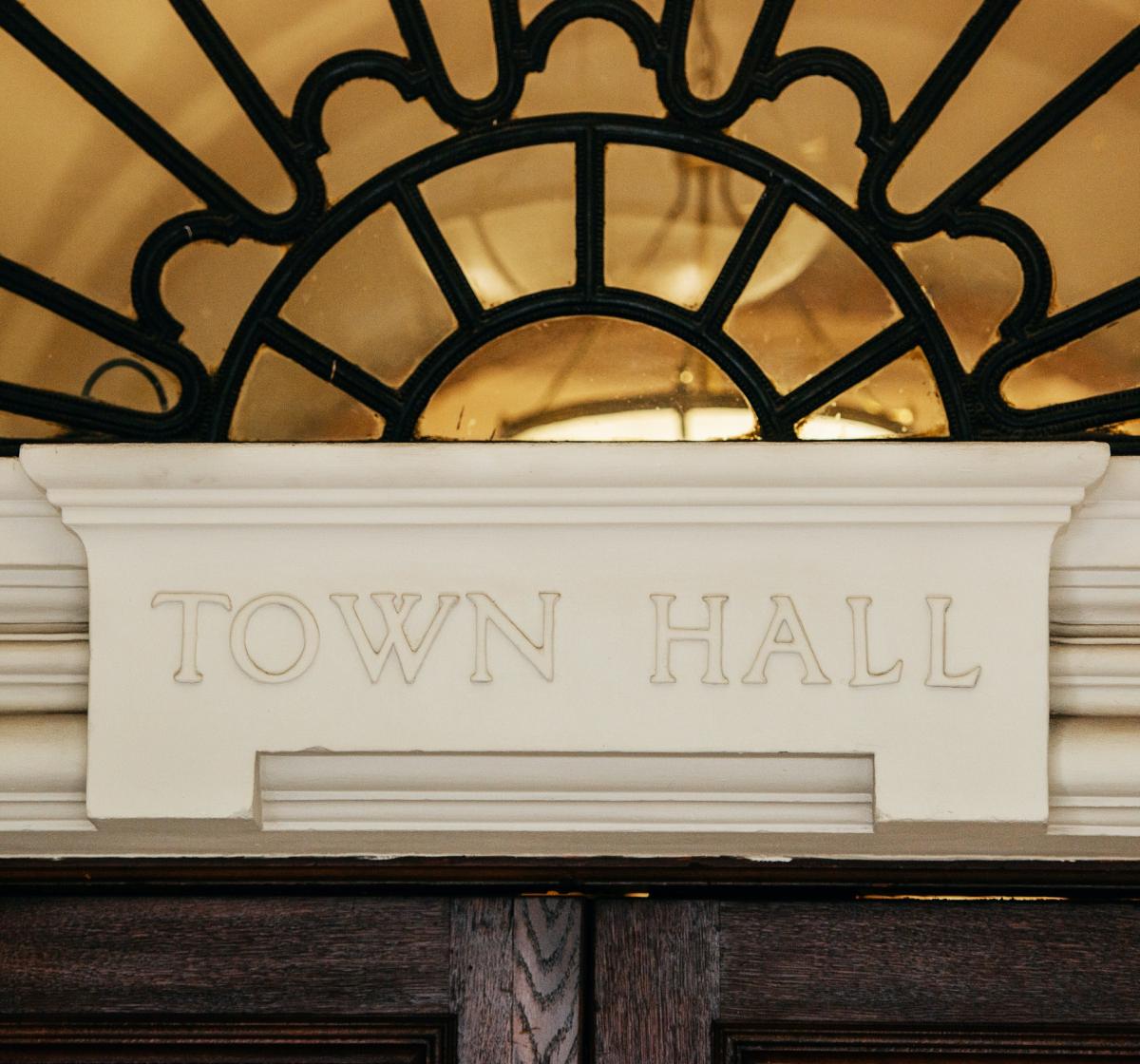 Photo of a town hall doorframe with the words Town Hall written on it.