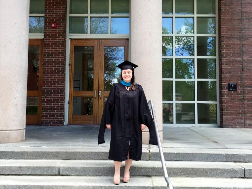 A photograph of Brittany Matthews on the steps of Dimond Library after graduating with her Master of Public Administration degree